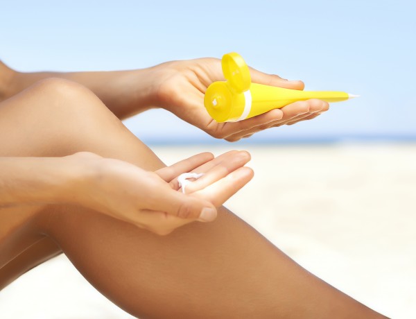 Woman applying sun cream to legs