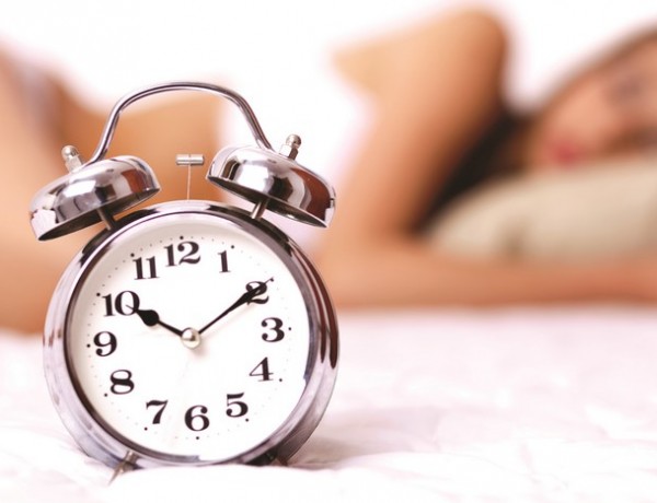 Clock-Closeup-Alarm-clock-african-woman-sleeping-in-background