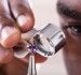 African-American jeweler examining diamond through loupe