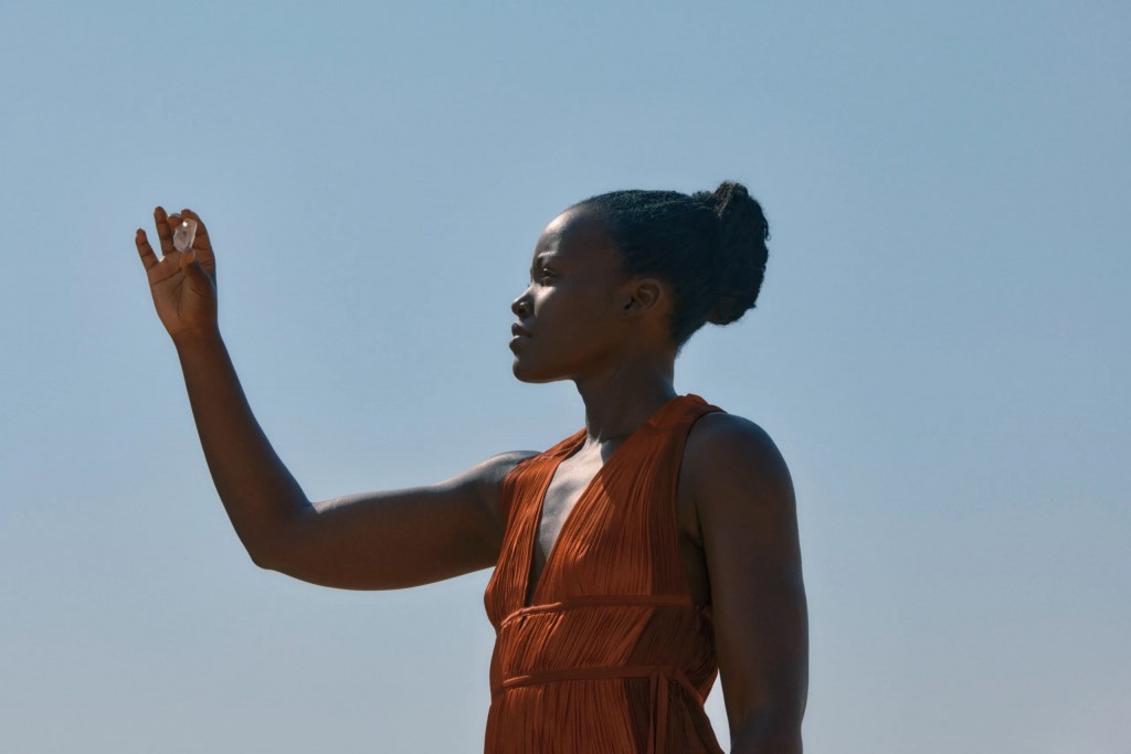 Lupita Nyongo'o looks at a De Beers diamond