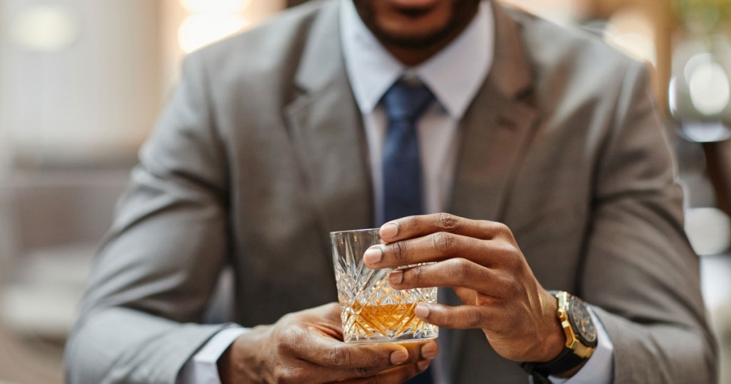 man holding a glass of whisky