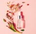 Serum in a bottle against a pink background